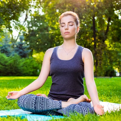 woman outdoors stretching meditating calming