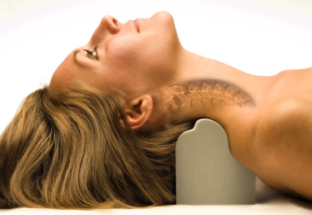 Patient lying on a Denneroll Cervical Orthotic Device for cervical extension traction