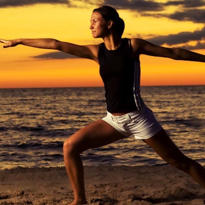 woman doing yoga on beach