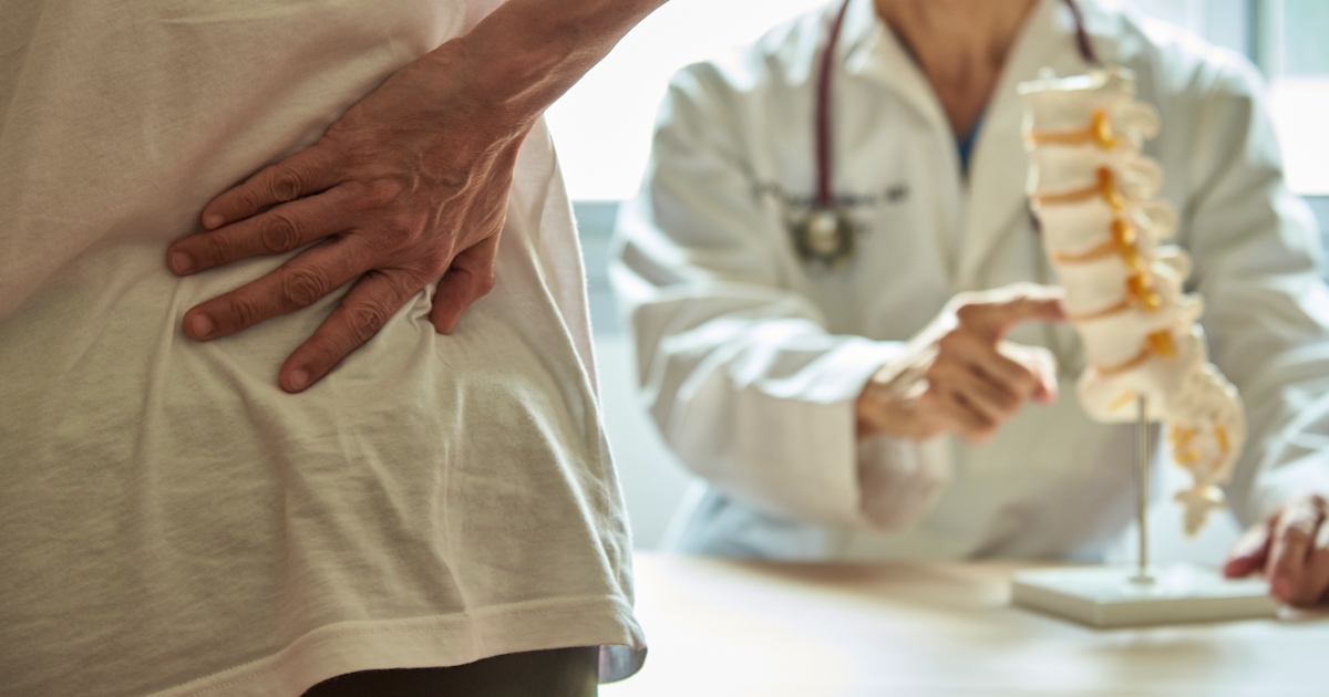 A doctor explaining lumbar anatomy to back pain pa