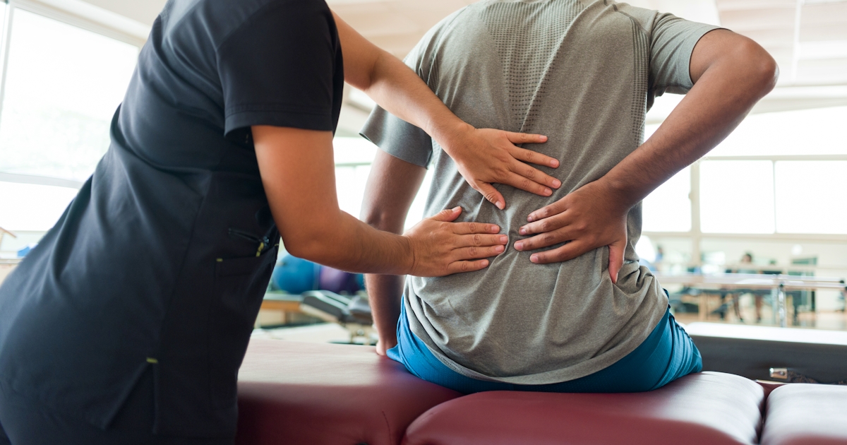 Female massage therapist massaging patients back