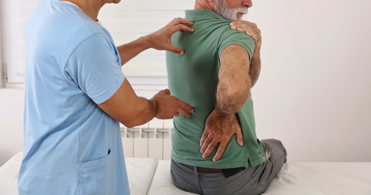 Senior man with back pain. Spine physical therapis