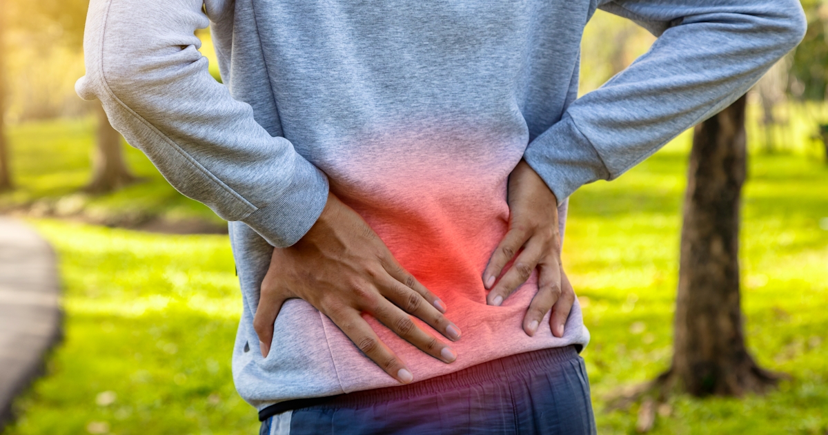 Sport man suffering from backache at park outdoors