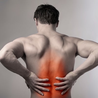 The image shows a muscular man seen from behind, holding his lower back with an orange highlight indicating pain or discomfort in that area.