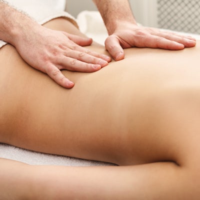 half of female body on table getting massage on low back