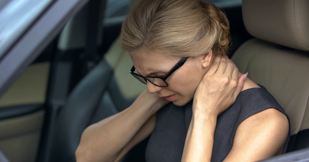 Exhausted woman feeling neck pain, sitting in auto