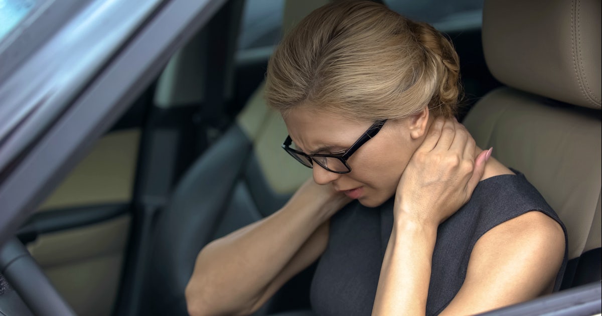 Exhausted woman feeling neck pain, sitting in auto