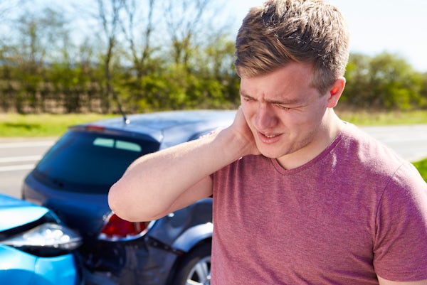 person holds neck in pain after auto collision