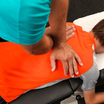 brunette male patient chiropractic adjustment male chiropractor