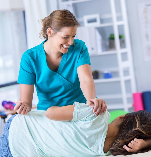 Chiropractor adjusts female patient