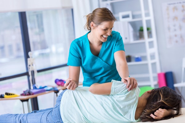 Chiropractor adjusts female patient