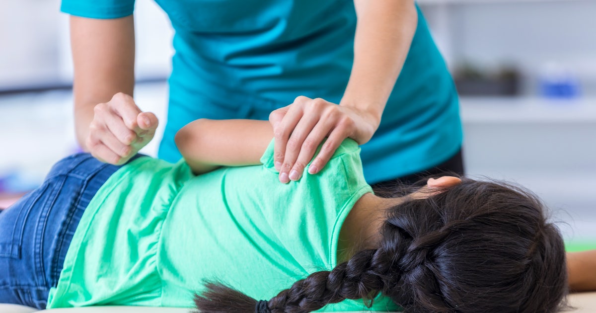Chiropractor adjusts young girls back