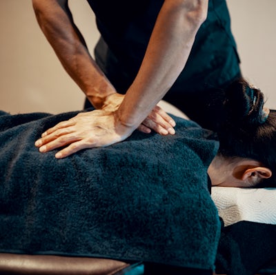 Mid adult male chiropractor treating a female pati