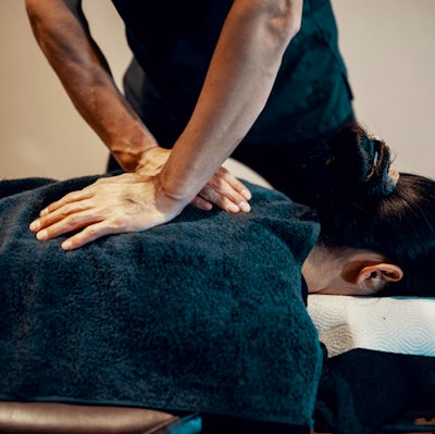 Mid adult male chiropractor treating a female pati