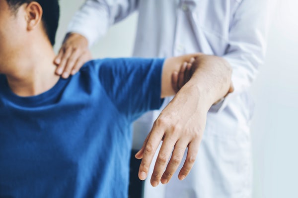 Doctor consulting with patient about shoulder pain
