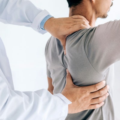 Physiotherapist doing healing treatment on mans ba