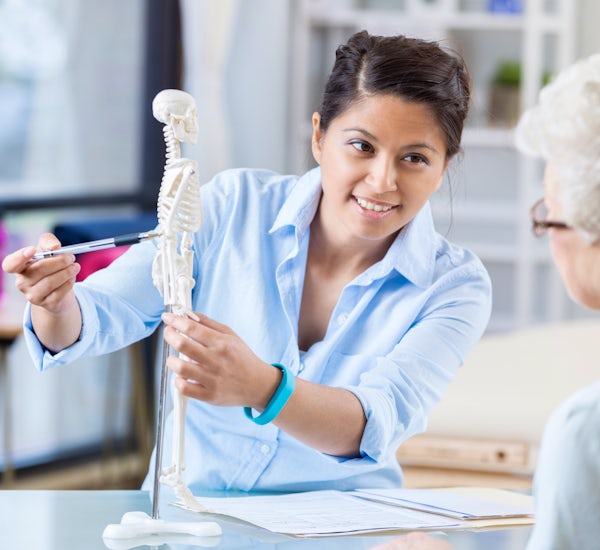 Young chiropractor explains treatment plan to seni