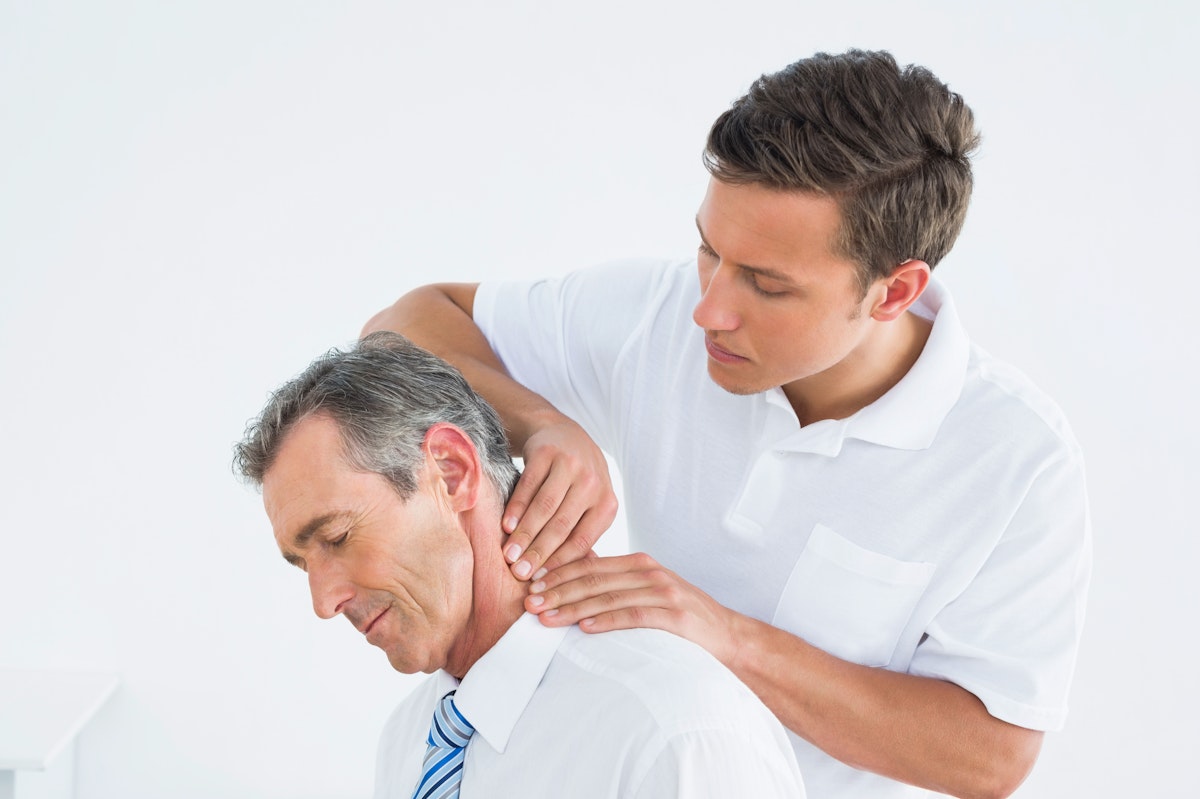 A chiropractor performs an adjustment on a patient with neck pain