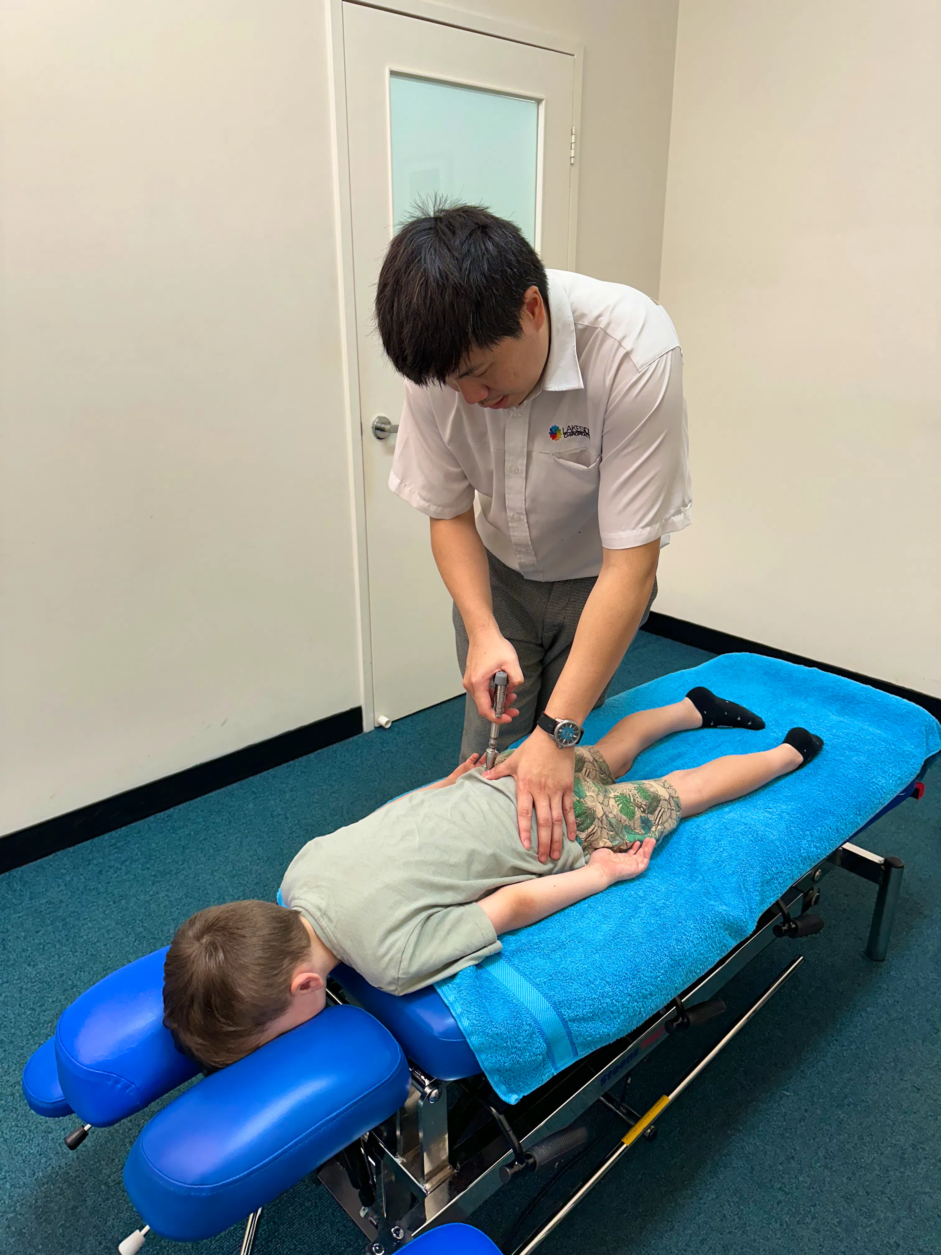 Chiropractor performing a gentle Activator Method adjustment on a young child at Lakeside Chiropractic