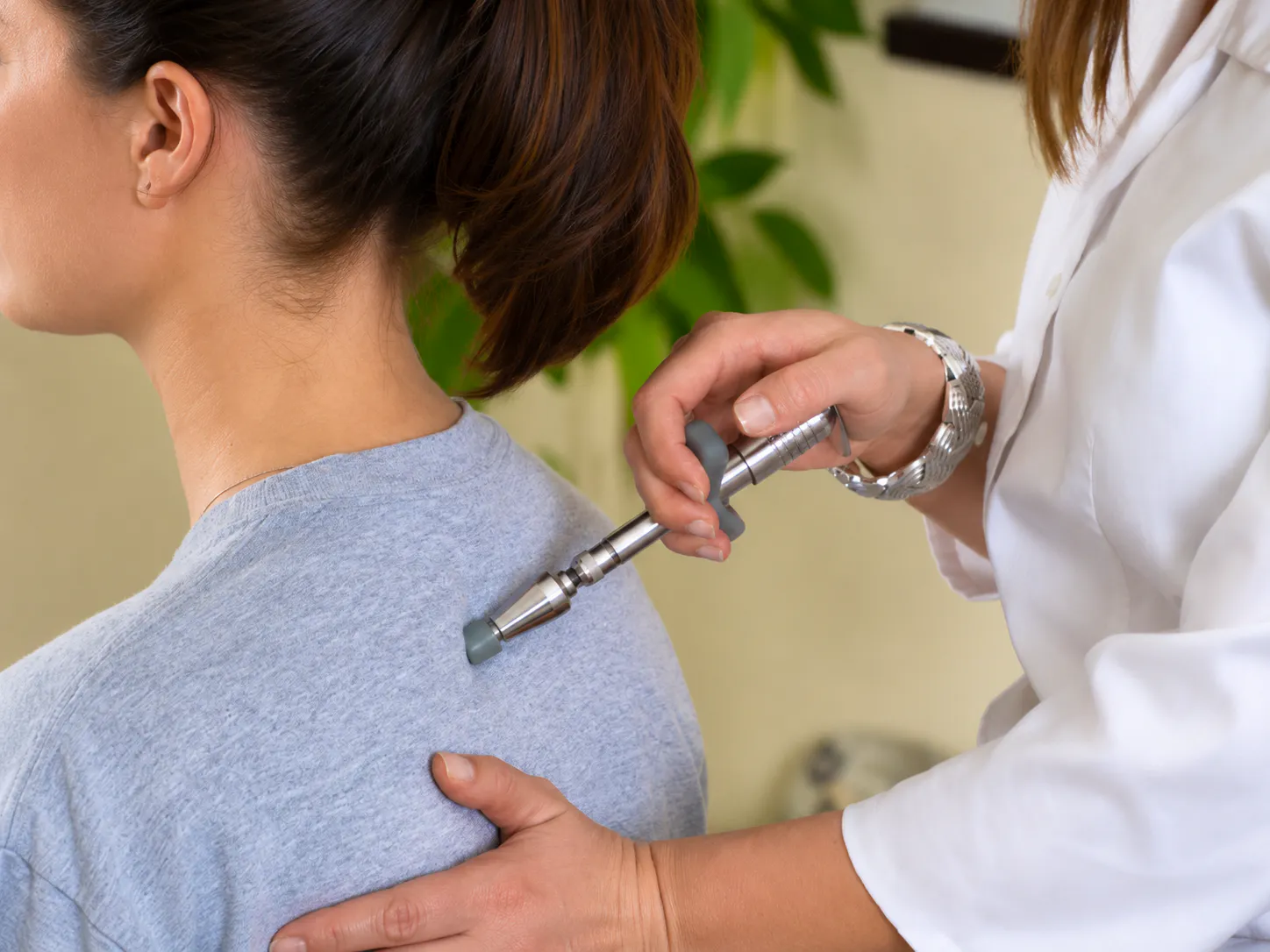 Chiropractor using an activator tool during cervical disc herniation and neck pain treatment in Joondalup