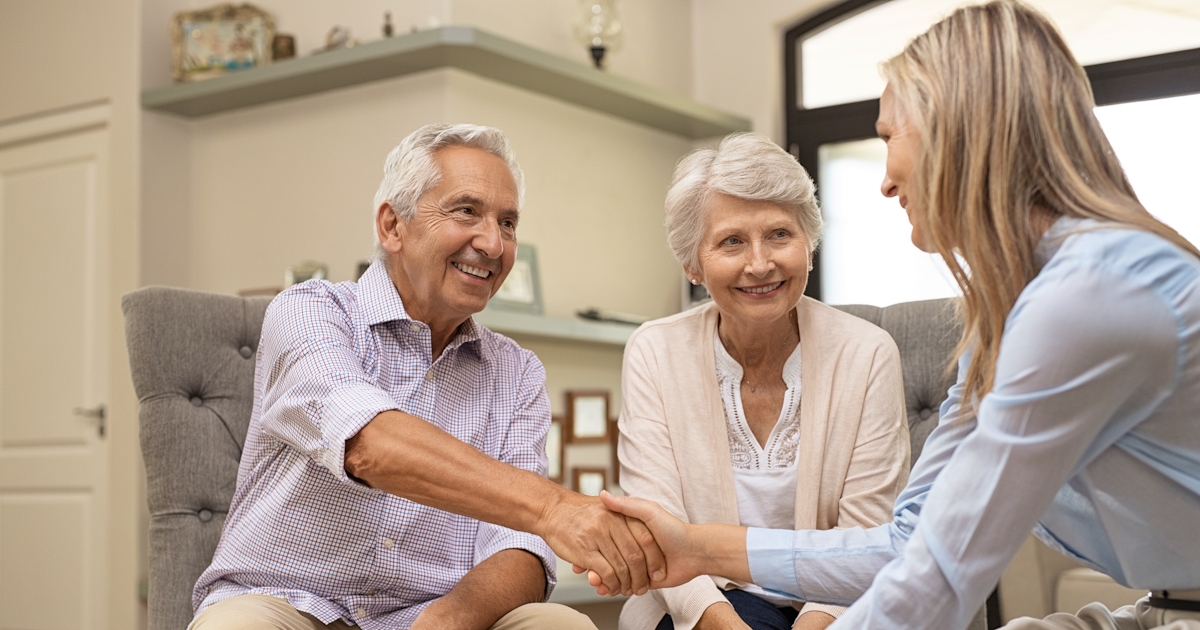 Senior couple shaking hands with financial advisor
