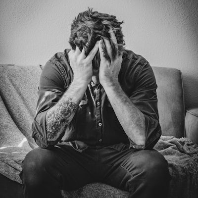 Stressed Man Holds Face in Hands