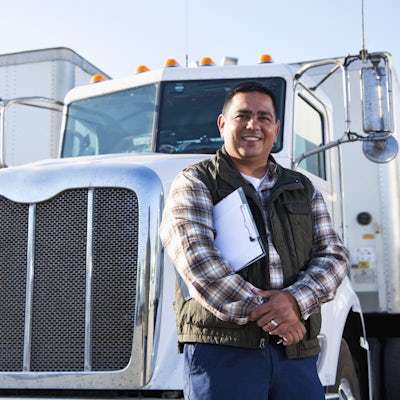 Hispanic truck driver with clipboard