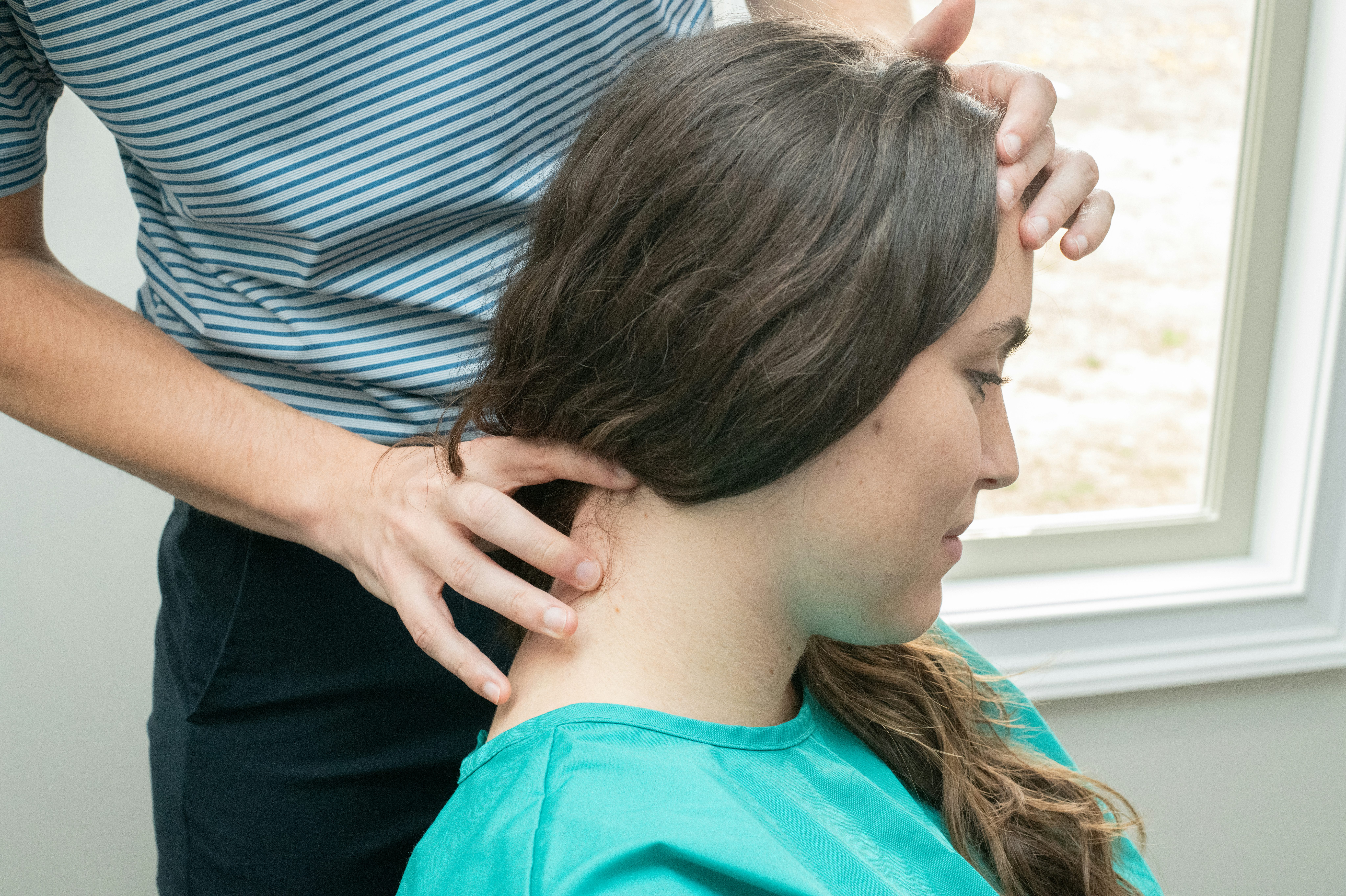 Dr. Hyde and Dr. Simon roleplaying as doctor and patient. Dr. Hyde is performs Craniosacral Fascial Therapy on a patient.