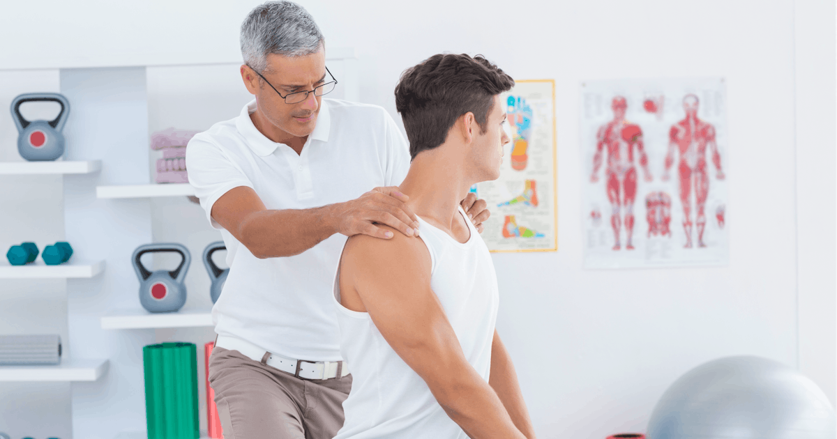 young white male seated on table chiropractic adjustment male chiropractor