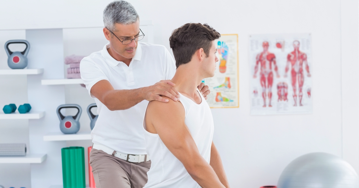 young white male seated on table chiropractic adjustment male chiropractor