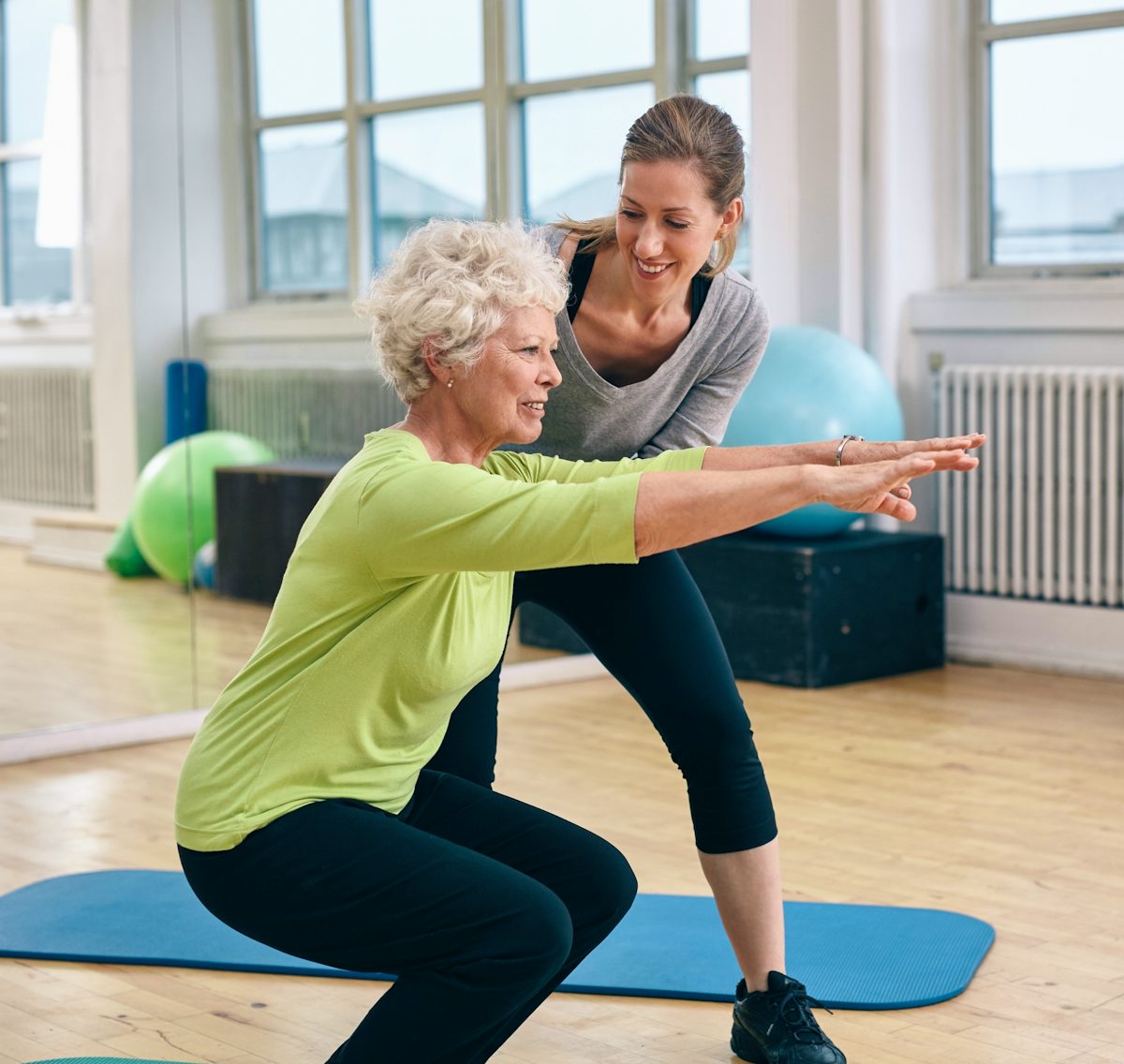 Elderly woman exercising with coach
