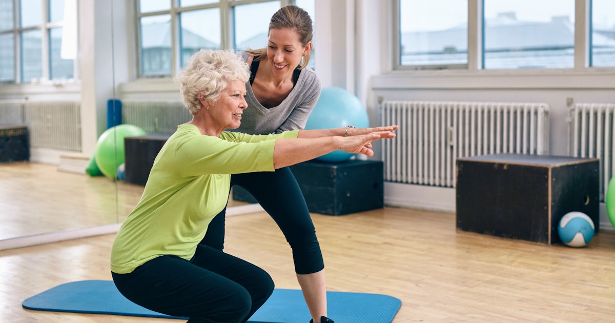 Elderly woman exercising with coach