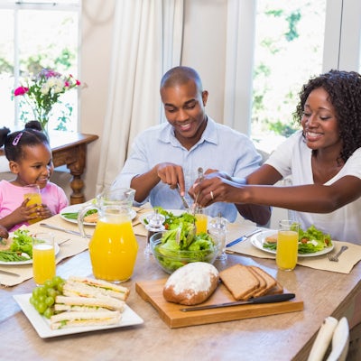 african american happy family at table eating healthy