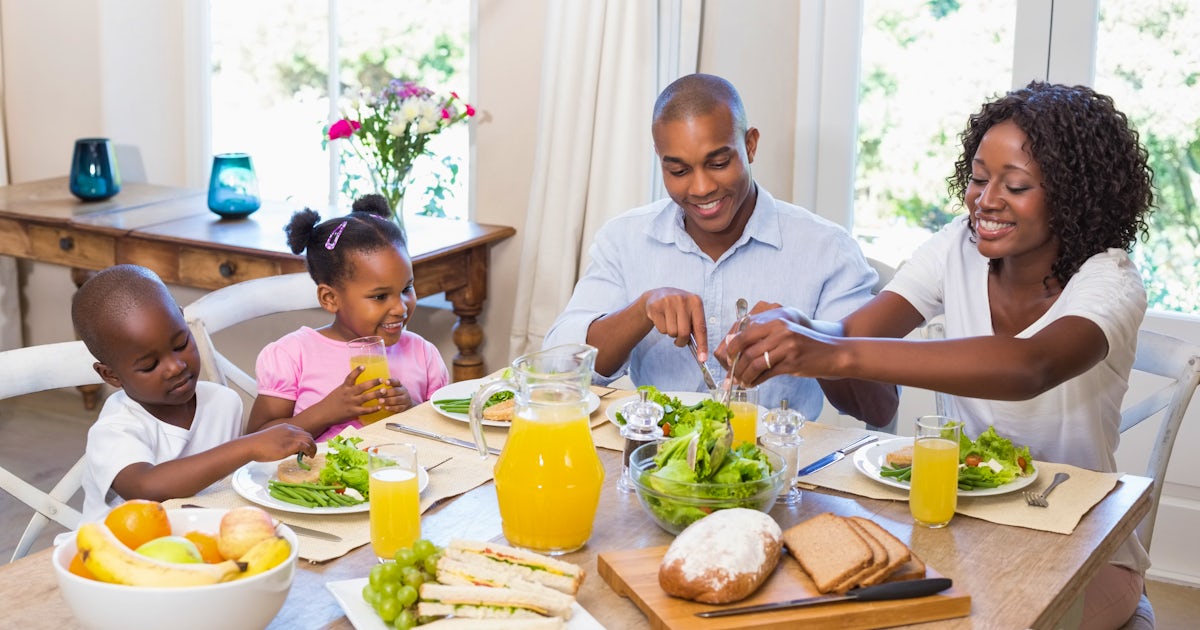 african american happy family at table eating healthy