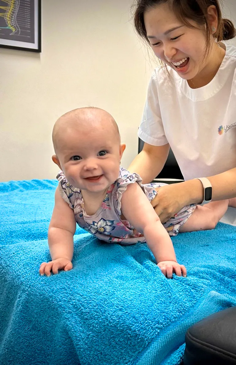 Happy baby smiling during a chiropractic assessment