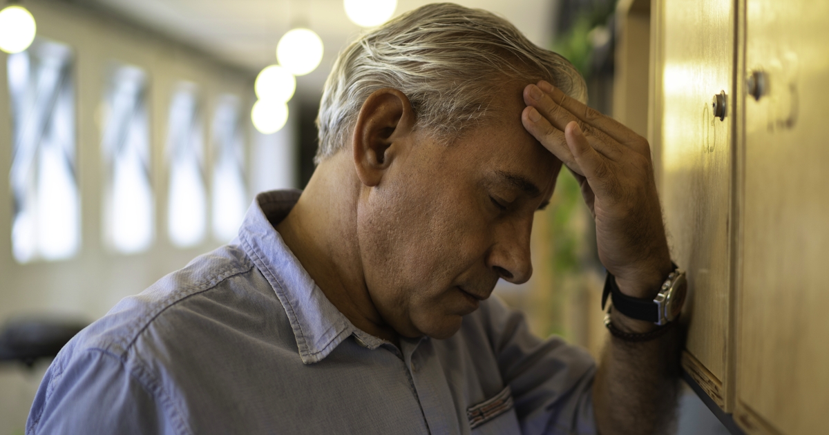 Frustrated senior businessman with headache at wor
