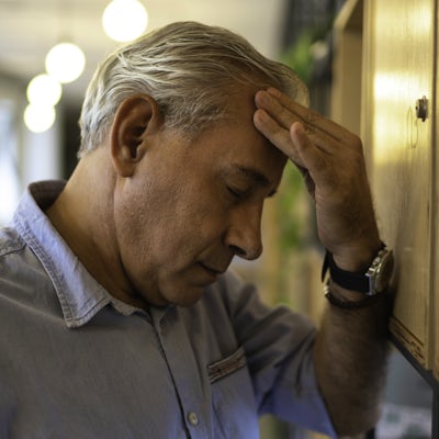 Frustrated senior businessman with headache at wor