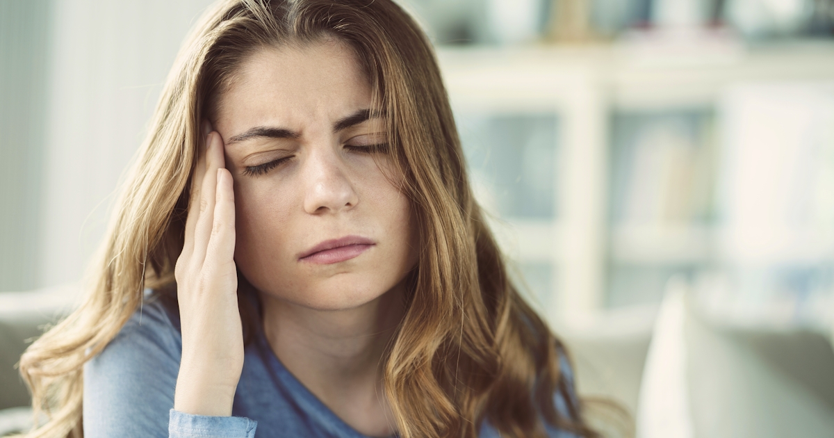 Young woman with headache in home interior