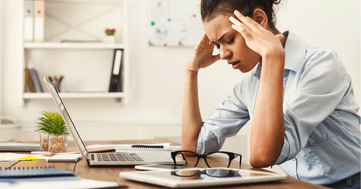 woman leaning over laptop with her head in her hands