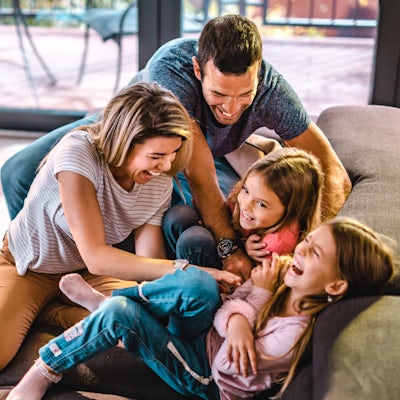 Above view of playful parents tickling their daugh