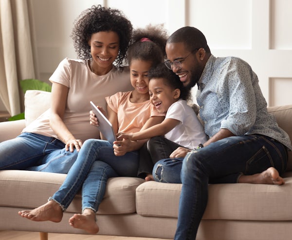 Happy black parents and children using digital tab