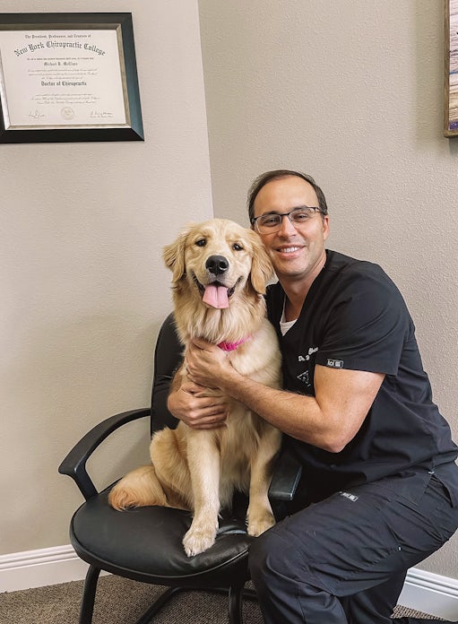 Dr. Michael McClure, Chiropractor of Lakes Chiropractic in Land O' Lakes, FL smiling with dog