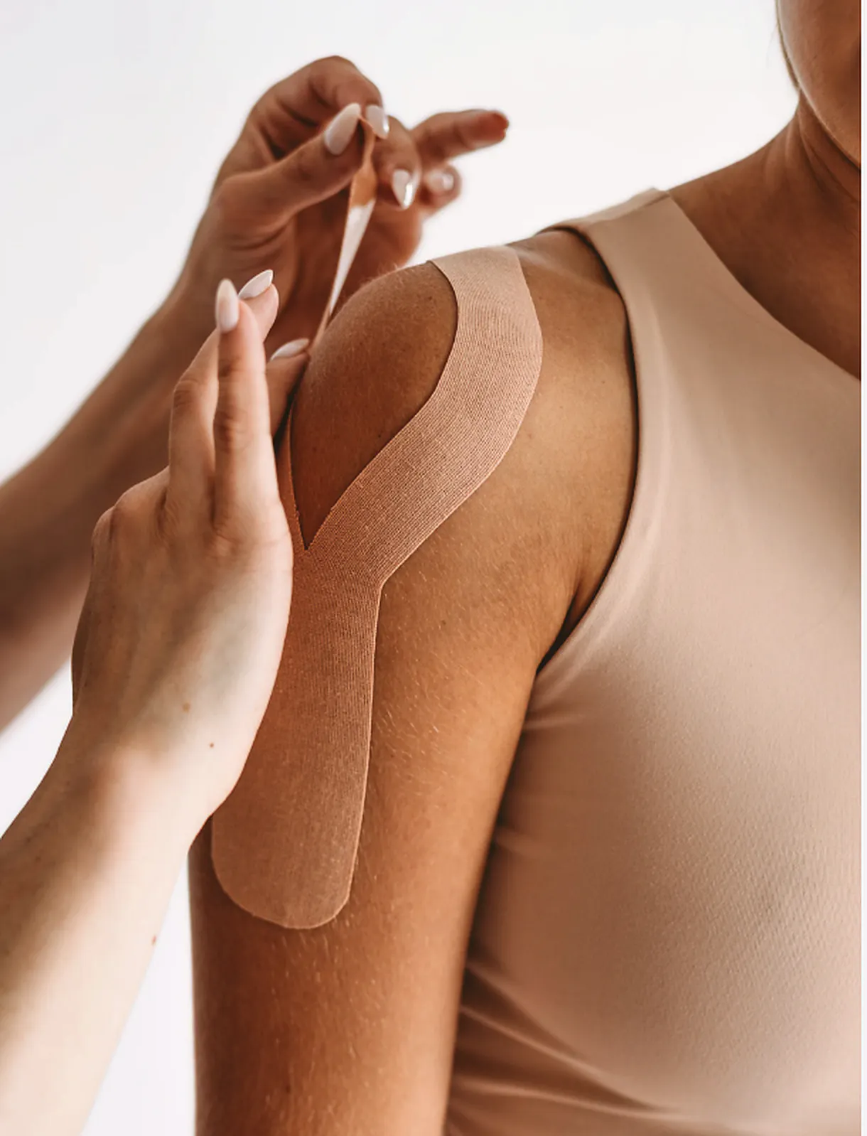 Kinesiology tape applied to the shoulder for frozen shoulder support, stiffness, and mobility care