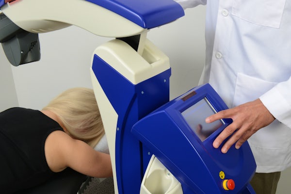 chiropractor using laser therapy machine on a patient's back