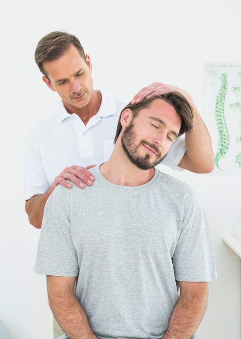 fit handsome man seated position getting chiropractic adjustment male chiropractor doctor