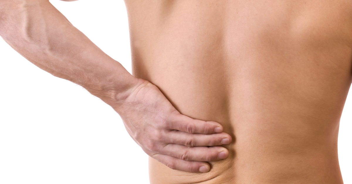 bare back of upper half of muscular white man with hand on lower back pain