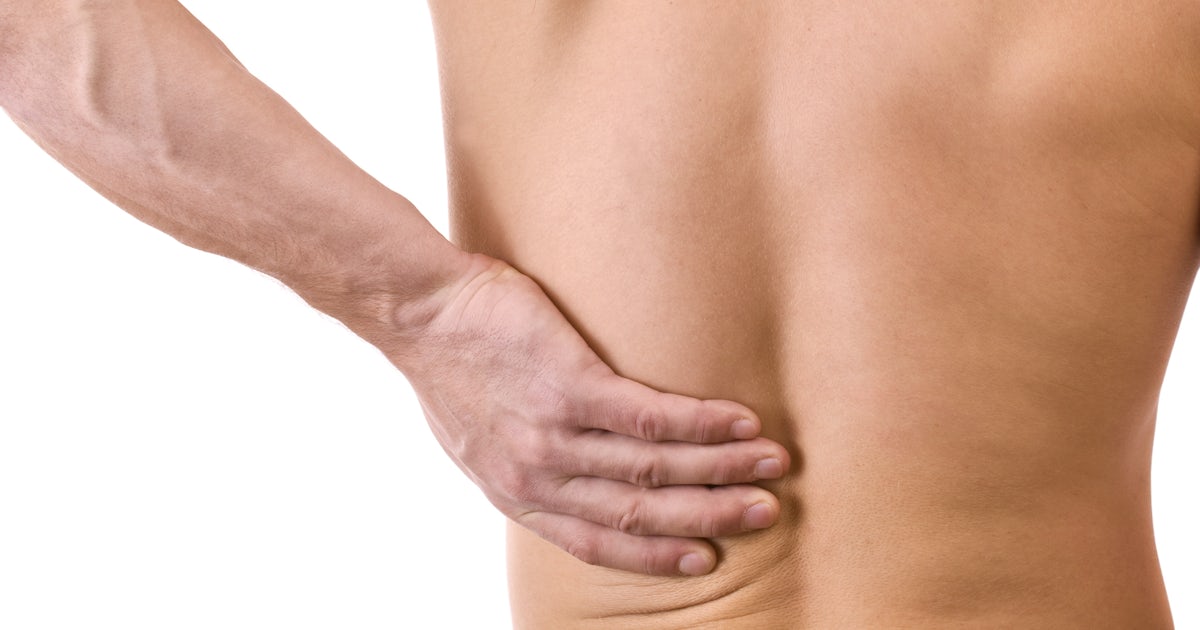 bare back of upper half of muscular white man with hand on lower back pain