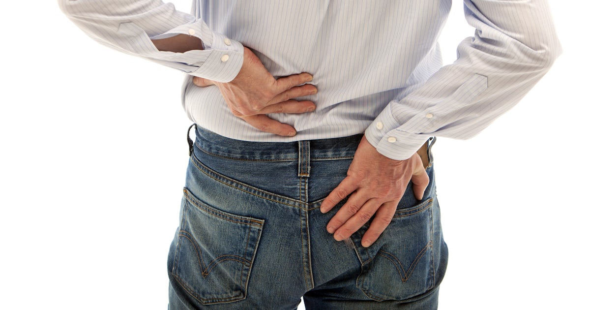clothed back of middle half of white man with both hands on lower back pain