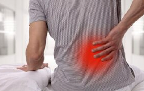 Man holding his lower back with mechanical low back pain and lumbar discomfort