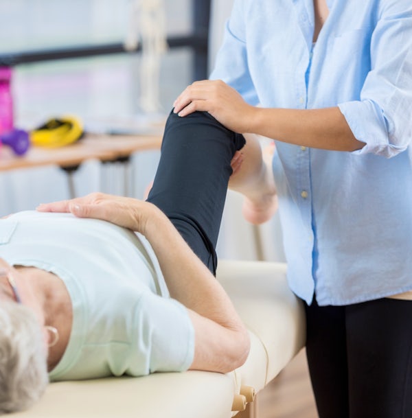 Unrecognizable chiropractor works on senior womans